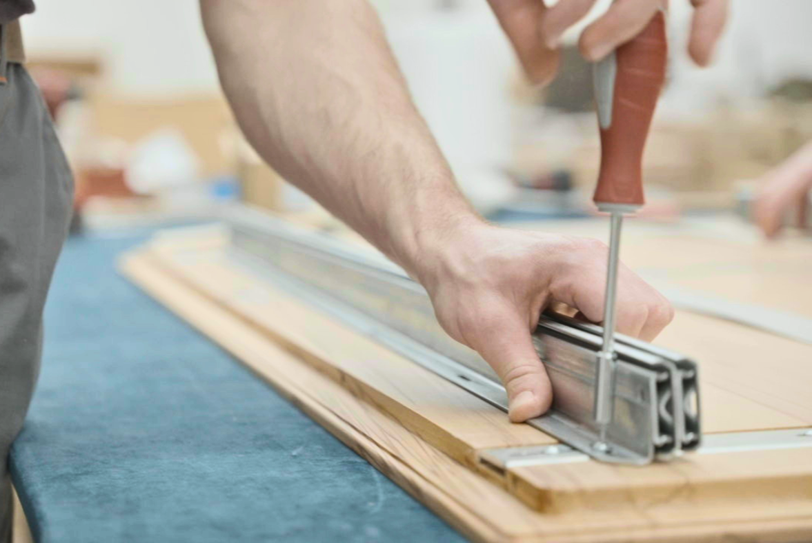 Ein Linea-D-Tischbauteil wird von Hand montiert